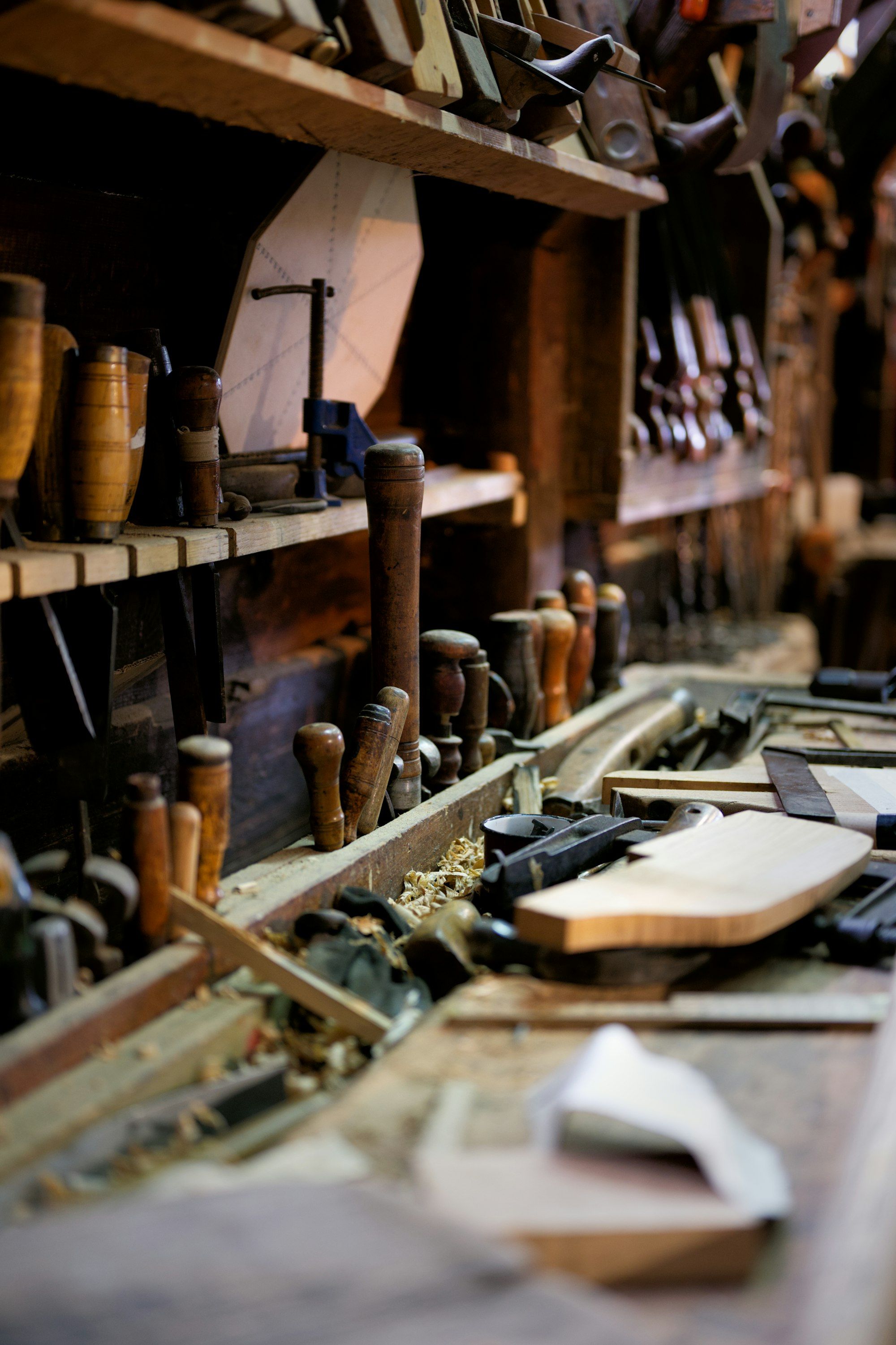 A well-used workbench covered with hand tools and clamps